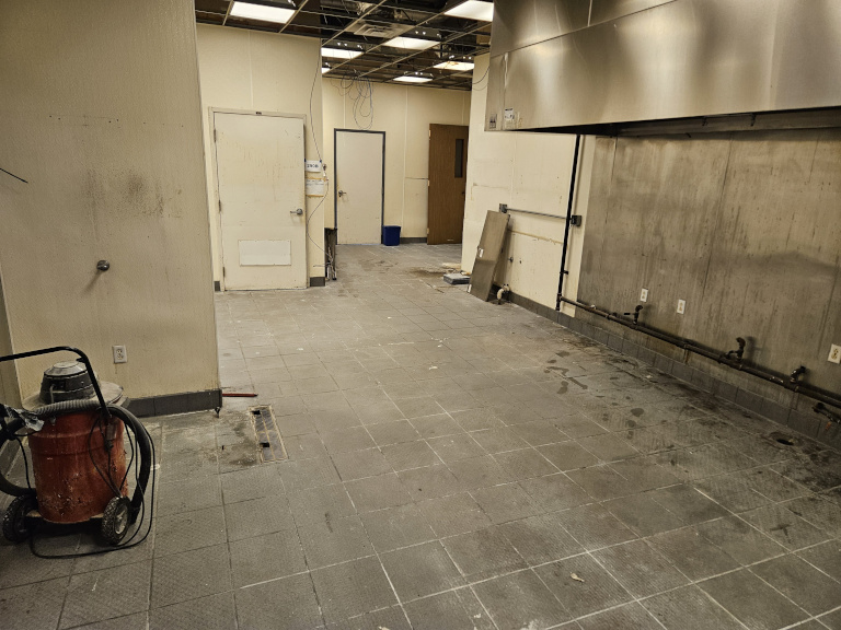 Commercial kitchen before — stripped and ready for renovation